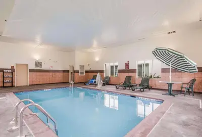 a large swimming pool with a table and chairs at Sleep Inn & Suites Ronks - Lancaster Area in Ronks