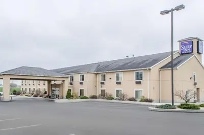 a hotel with a sign in a parking lot at Sleep Inn & Suites Ronks - Lancaster Area in Ronks