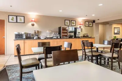 a restaurant with tables and chairs and a kitchen at Sleep Inn & Suites Ronks - Lancaster Area in Ronks