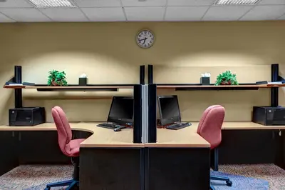 an office with two desks with pink chairs and a clock at Hyatt House Philadelphia/Plymouth Meeting in East Norriton