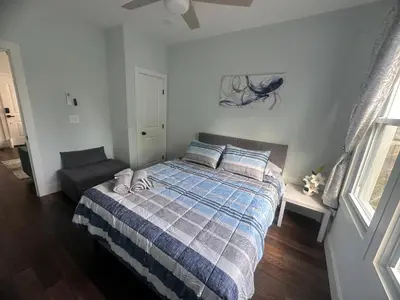 a bedroom with a bed with a blue and gray blanket at MetLife Stadium Apartments Near NYC in Jersey City