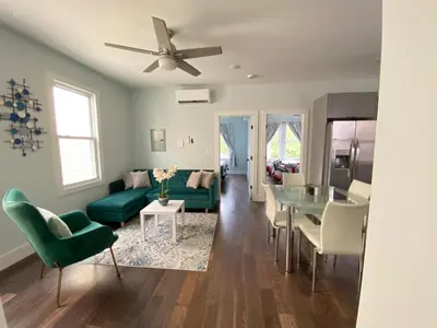 a living room with a green couch and a table at MetLife Stadium Apartments Near NYC in Jersey City