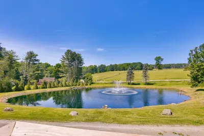 a large pond with a fountain in the middle at Delaware River Access Peaceful Farm Retreat! in Callicoon