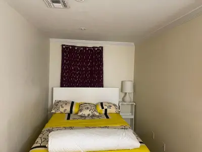 a bedroom with a bed with yellow sheets and a window at Peculiar 96 in Newark