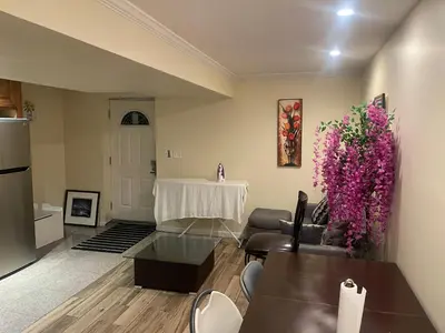 a living room with a table and purple flowers at Peculiar 96 in Newark