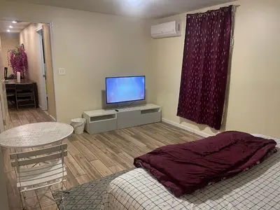 a living room with a flat screen tv and a table at Peculiar 96 in Newark