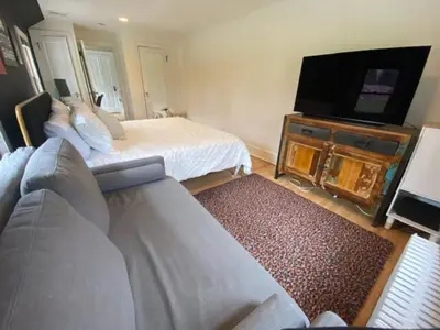 a bedroom with a bed and a flat screen tv at Enchanting Historic Home near West Point Beacon in Cornwall-on-Hudson