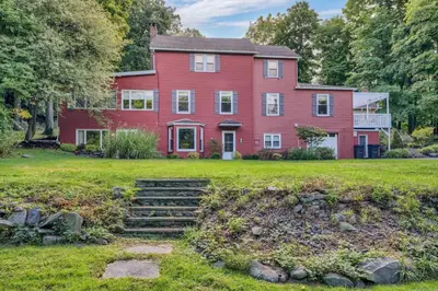a large red house with a grass yard at Enchanting Historic Home near West Point Beacon in Cornwall-on-Hudson