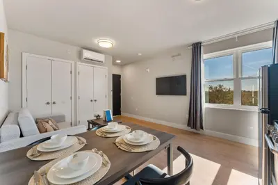 a living room with a table and chairs and a couch at 4211 Suites in Philadelphia