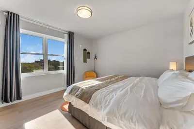 a bedroom with a bed and a large window at 4211 Suites in Philadelphia