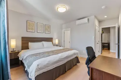 a bedroom with a large bed and a desk at 4211 Suites in Philadelphia
