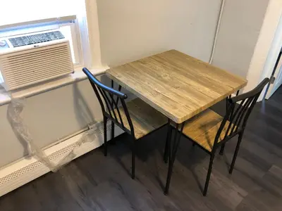 a wooden table and two chairs next to a window at Private 2-bedroom apartment, free parking, direct bus to NYC Manhattan only 2 blocks away, MetLife Stadium FIFA World Cup 25 minutes away in Linden