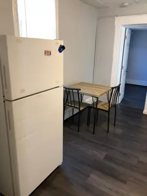 a refrigerator and a table in a room at Private 2-bedroom apartment, free parking, direct bus to NYC Manhattan only 2 blocks away, MetLife Stadium FIFA World Cup 25 minutes away in Linden