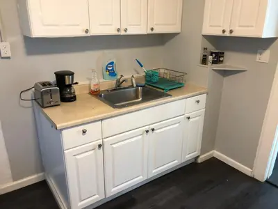 a kitchen with white cabinets and a sink at Private 2-bedroom apartment, free parking, direct bus to NYC Manhattan only 2 blocks away, MetLife Stadium FIFA World Cup 25 minutes away in Linden
