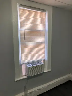 an empty room with a window with an air conditioner at Private 2-bedroom apartment, free parking, direct bus to NYC Manhattan only 2 blocks away, MetLife Stadium FIFA World Cup 25 minutes away in Linden