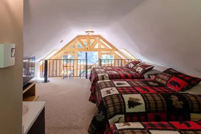 two beds in a room with a large window at Hot Tub l Walk to Lake Harmony l Minutes to Ski in Lake Harmony