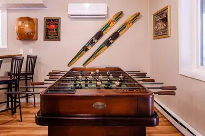 a room with a pool table and baseball bats on the wall at Hot Tub l Walk to Lake Harmony l Minutes to Ski in Lake Harmony
