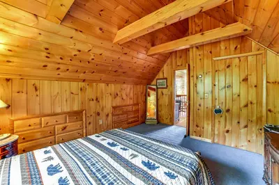 a bedroom with a bed in a wooden cabin at Secluded Oxford Cabin on 75 Acres Sunset Views! in Oxford