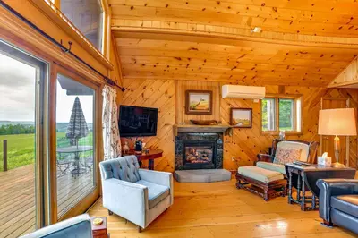a living room with a fireplace in a log cabin at Secluded Oxford Cabin on 75 Acres Sunset Views! in Oxford