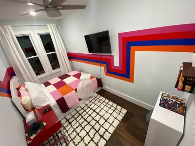 a bedroom with a bed and a colorful wall at Heart of NY - 17 min to Empire State & Times Sq in Jersey City