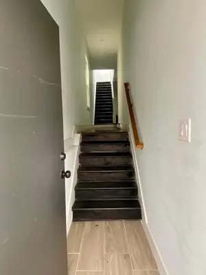 a hallway with a stairway with a set of stairs at Heart of NY - 17 min to Empire State & Times Sq in Jersey City
