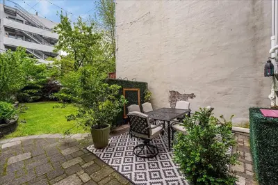 a patio with a table and chairs in a yard at Artist Residence 3 Bedroom Brownstone in Hoboken