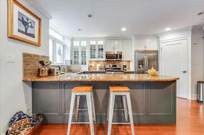 a kitchen with a large island with two bar stools at Artist Residence 3 Bedroom Brownstone in Hoboken