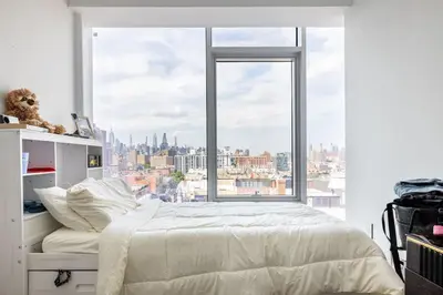 a bedroom with a large window with a city view at Travive New York Brand New Five Bedroom Penthouse in New York
