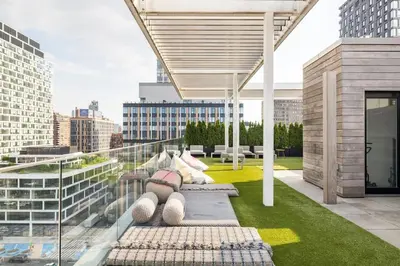 a rooftop patio with benches on a building at Travive New York Brand New Five Bedroom Penthouse in New York