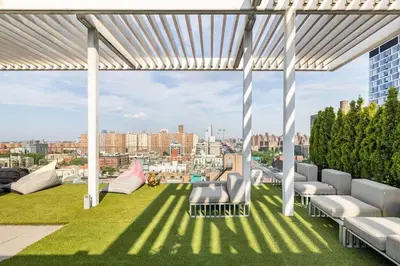 a rooftop patio with chairs and a view of a city at Travive New York Brand New Five Bedroom Penthouse in New York
