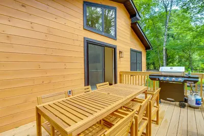 a wooden deck with a picnic table and a grill at Private Hot Tub Charming Poconos Cabin! in Albrightsville