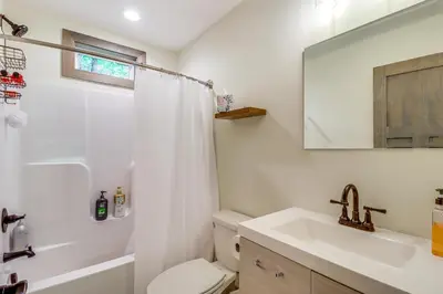 a bathroom with a sink and a toilet and a mirror at Private Hot Tub Charming Poconos Cabin! in Albrightsville