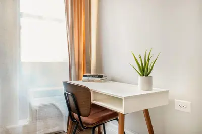 a white desk with a plant on it next to a window at 73-410 Luxury 24 DM New Studio UWS Gym Laundry in New York