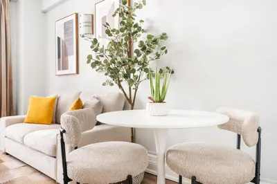 a living room with a couch and a table and chairs at 73-406 New 1BR 1Bth UWS Doorman Gym in New York