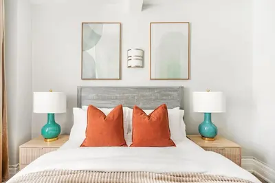 a bedroom with a bed with orange pillows and two lamps at 73-406 New 1BR 1Bth UWS Doorman Gym in New York
