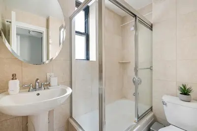 a bathroom with a shower and a sink and a toilet at 73-406 New 1BR 1Bth UWS Doorman Gym in New York