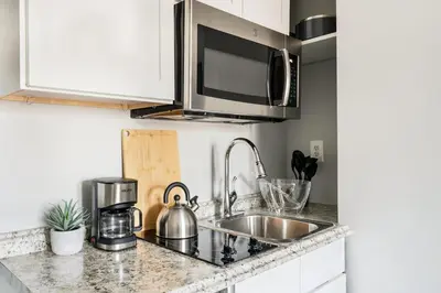 a kitchen counter with a sink and a microwave at 73-1111 New Studio UWS Doorman Gym in New York
