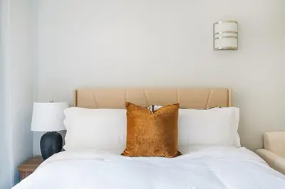 a bed with white sheets and brown pillows at 73-1111 New Studio UWS Doorman Gym in New York