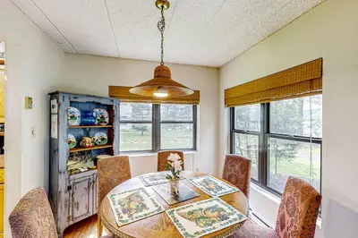 a dining room with a table and some windows at Marvel at Midlake in Lake Harmony
