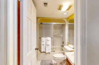 a bathroom with a toilet and a tub and a sink at Marvel at Midlake in Lake Harmony