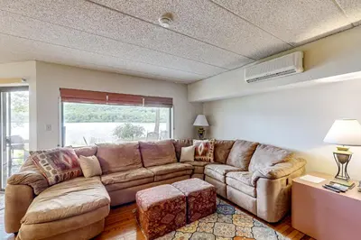 a living room with a brown couch and a window at Marvel at Midlake in Lake Harmony