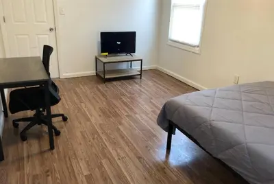 a bedroom with a desk and a bed and a desk with a chair at Private apartment with 3 bedrooms and 1 bathroom near Newark International Airport EWR and New York City, MetLife Stadium FIFA World Cup 20 minutes away in Newark