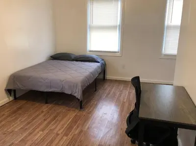 a bedroom with a bed and a table in it at Private apartment with 3 bedrooms and 1 bathroom near Newark International Airport EWR and New York City, MetLife Stadium FIFA World Cup 20 minutes away in Newark
