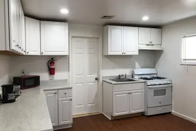 a kitchen with white cabinets and a stove top oven at Private apartment with 3 bedrooms and 1 bathroom near Newark International Airport EWR and New York City, MetLife Stadium FIFA World Cup 20 minutes away in Newark