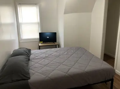 a bedroom with a large bed and a television at Private apartment with 3 bedrooms and 1 bathroom near Newark International Airport EWR and New York City, MetLife Stadium FIFA World Cup 20 minutes away in Newark
