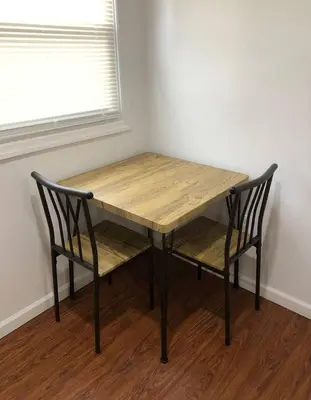 a wooden table and two chairs in a room at Private apartment with 3 bedrooms and 1 bathroom near Newark International Airport EWR and New York City, MetLife Stadium FIFA World Cup 20 minutes away in Newark