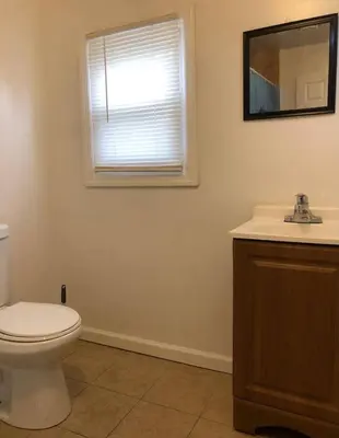 a bathroom with a toilet and a sink and a window at Private apartment with 3 bedrooms and 1 bathroom near Newark International Airport EWR and New York City, MetLife Stadium FIFA World Cup 20 minutes away in Newark