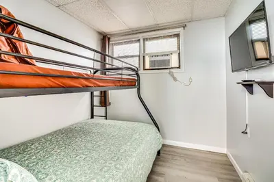 a small bedroom with a bunk bed and a tv at Cozy Keansburg Cottage Walk to Beach and Boardwalk! in Keansburg