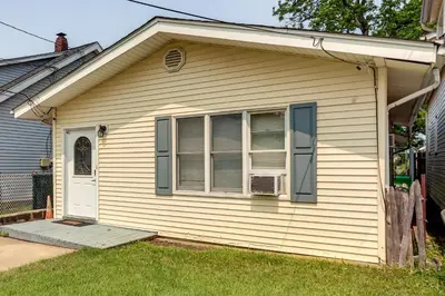 a white house with a window and a door at Cozy Keansburg Cottage Walk to Beach and Boardwalk! in Keansburg