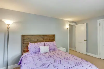 a bedroom with a purple bed with a wooden headboard at 10 Mi to Hersheypark Updated Family Retreat! in Annville